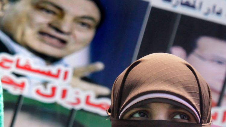 Eine Demonstrantin unter einem Anti-Mubarak-Plakat auf dem Tahrir-Platz, dem Zentrum des ägyptischen Aufstand in Kairo.