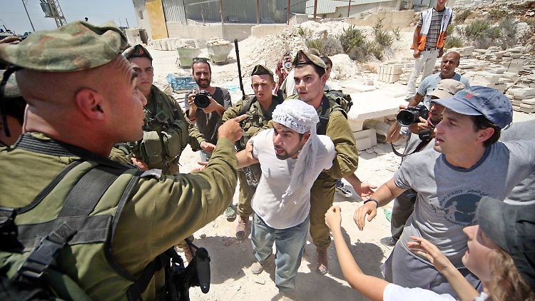 Ein israelischer Soldat im Clinch mit demonstrierenden Palästinensern.