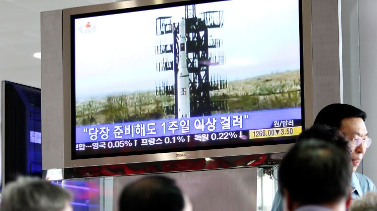 Südkoreaner beobachten einen nordkoreanischen  Raketenstart. Auf dem Fernsehschirm steht: "In einer Woche sind die Langstrecken-Raketen startklar."