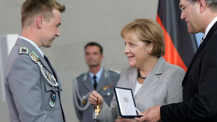 Leistungen, "die weit über das erwartete Maß an Tapferkeit im Rahmen der Pflichterfüllung hinausgehen": Kanzlerin Merkel bei der Verleihung des Ehrenkreuzes.
