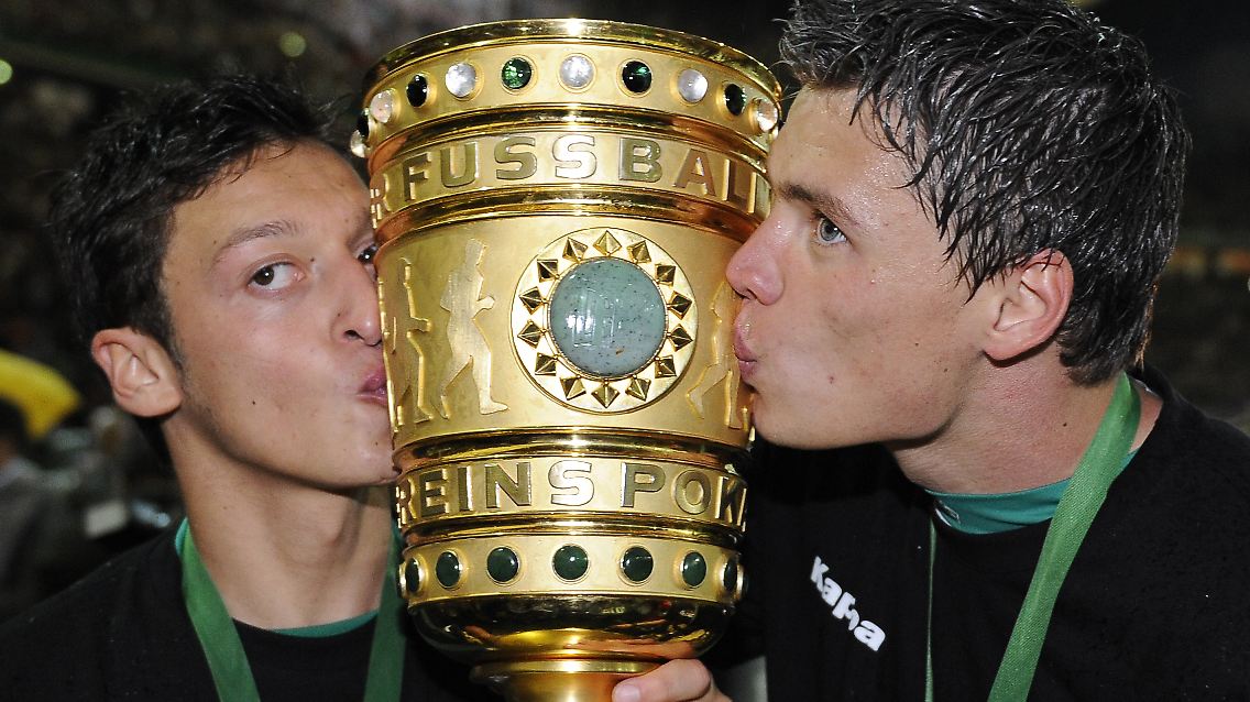 Um ihn geht es: Die Bremer Sebastian Boenisch (r) und Mesut Özil küssen den Pokal nach dem gewonnenen Finale.