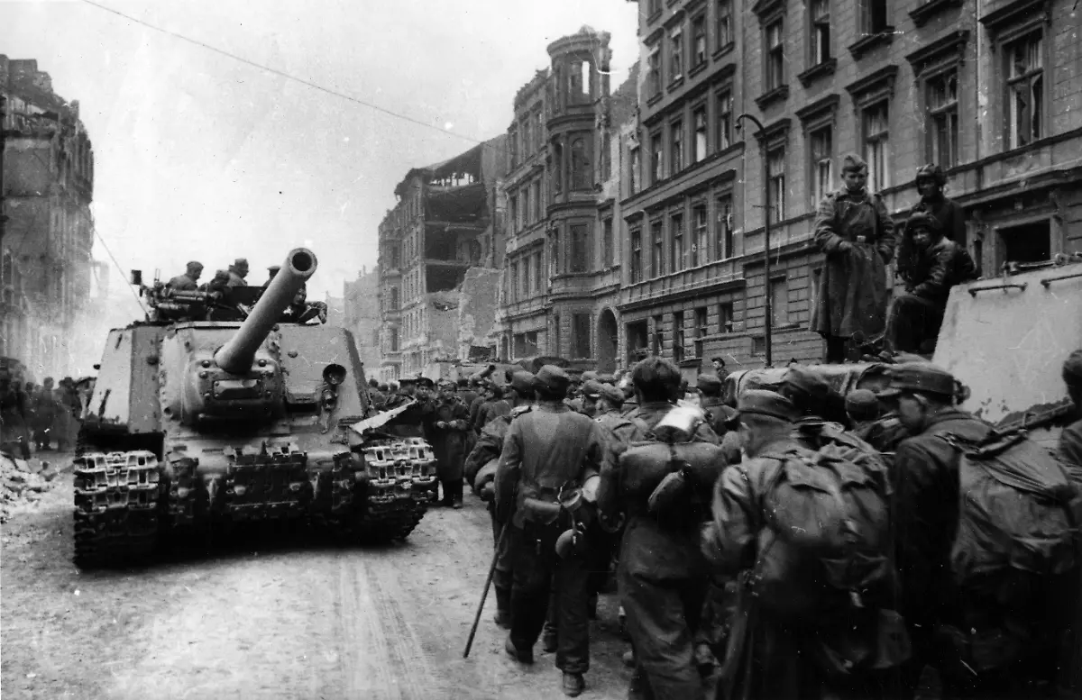 19829729-jpg-Deutsche-Gefangene-marschieren-in-Berlin-durch-eine-Strasse-mit-teils-zerstoerten-Gebaeuden-an-einem-Panzer-und-sowjetischen-Soldaten-vorbei-undatiertes-Foto-vom-Kriegsende-1945
