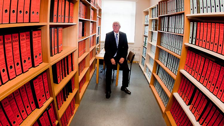 Klaus Scheuer, Präsident des Landgerichtes Frankfurt am Main, sitzt in einem Raum zwischen rund 600 Aktenordnern.