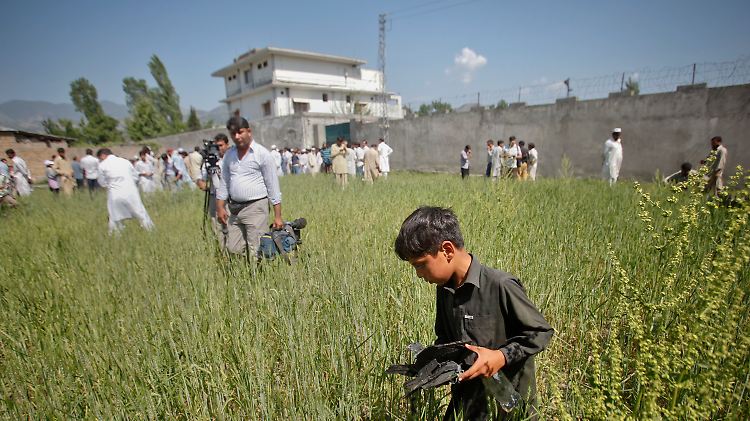 Terrorversteck in Abbottabad: Kinder bergen am Morgen danach Trümmerteile aus der Umgebung.
