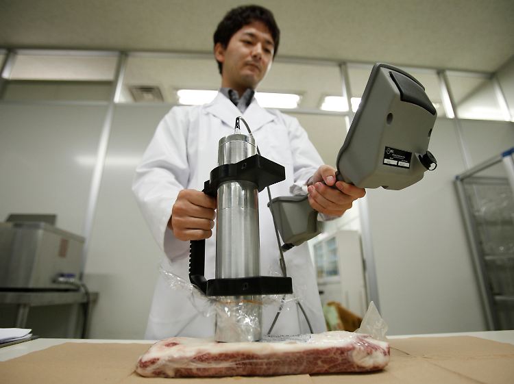 Die Angst isst mit: Ein Mitarbeiter der Gesundheitsbehörde überprüft Fleisch auf Kontamination.