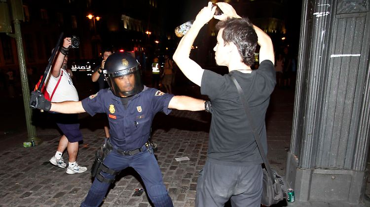 Ein Polizist und ein Demonstrant in Madrid.