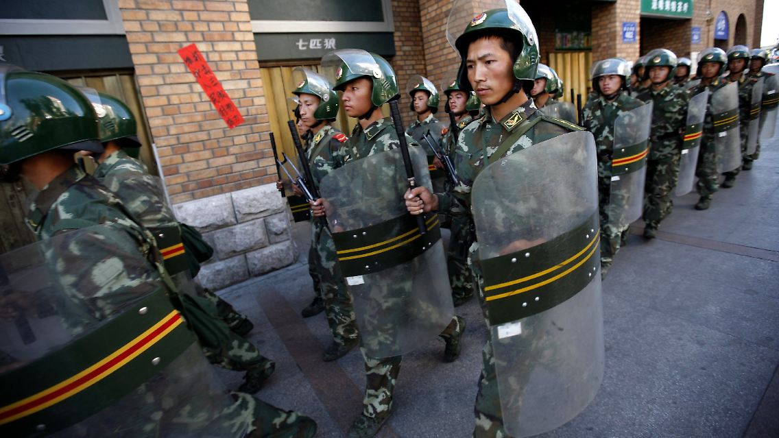Chinesische Soldaten riegeln Straßen zu uigurischen Vierteln ab.