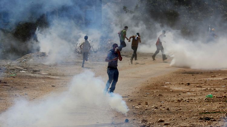Palästinenser flüchten in der Westbank vor einer Wolke von Tränengas. 