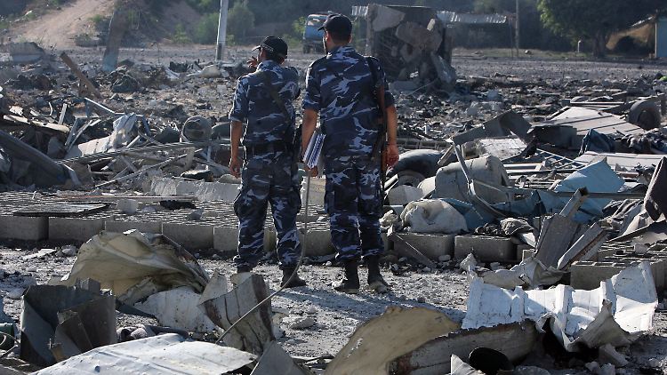 Zwei Sicherheitskräfte der Hamas untersuchen das Maß der Zerstörung.
