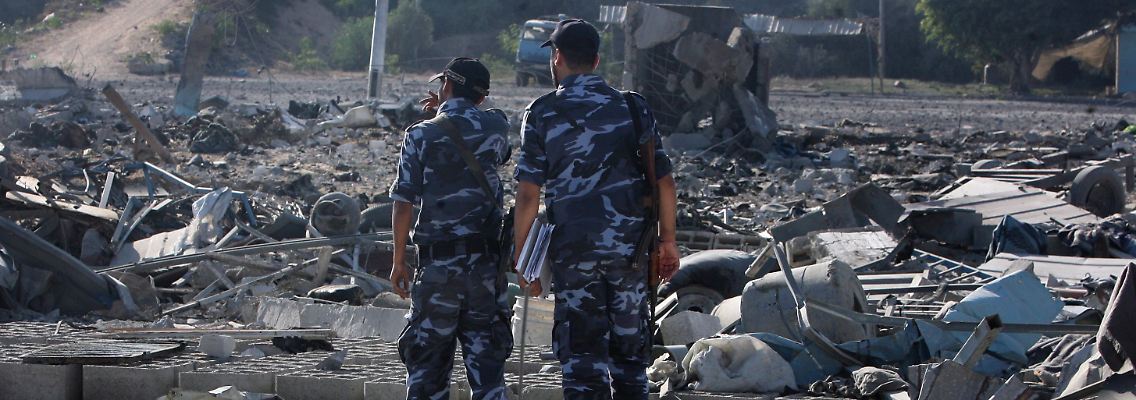 Zwei Sicherheitskräfte der Hamas untersuchen das Maß der Zerstörung.