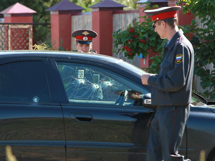 Polizisten untersuchen das Auto Duschkos.