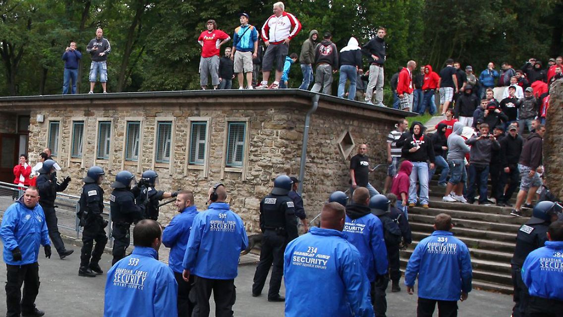 Tatort Erfurt: Vor Beginn der zweiten Halbzeit geraten Fans beider Fanlager hinter dem Marathontor aneinander, Polizeibeamte und Mitarbeiter des Stadionsicherheitsdienstes versuchen das zu verhindern.