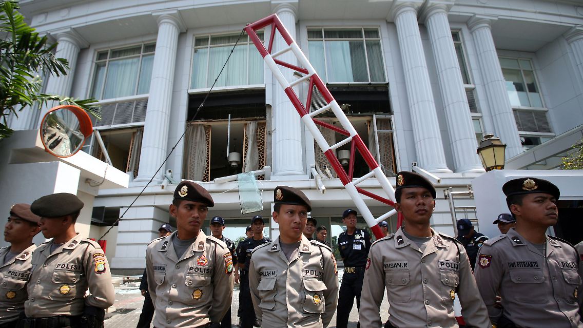 Indonesische Sicherheitskräfte vor der zerstörten Fassade des Ritz-Carlton-Hotels.