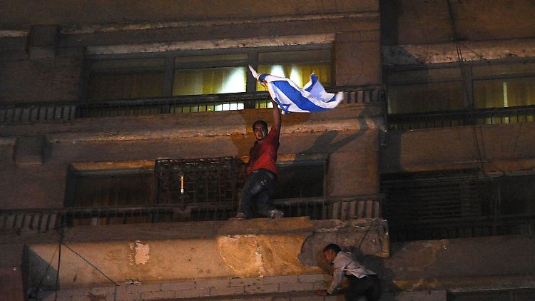 Ein Ägypter entfernt die israelische Flagge.