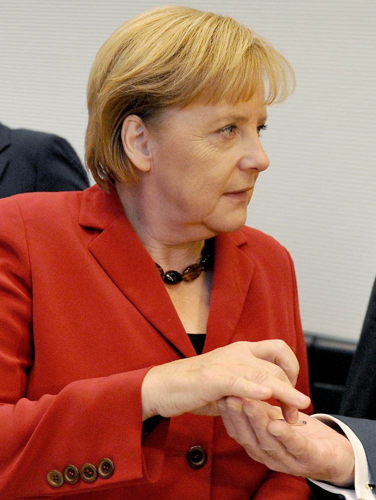 Merkel übergibt Zwegatos das Geld.