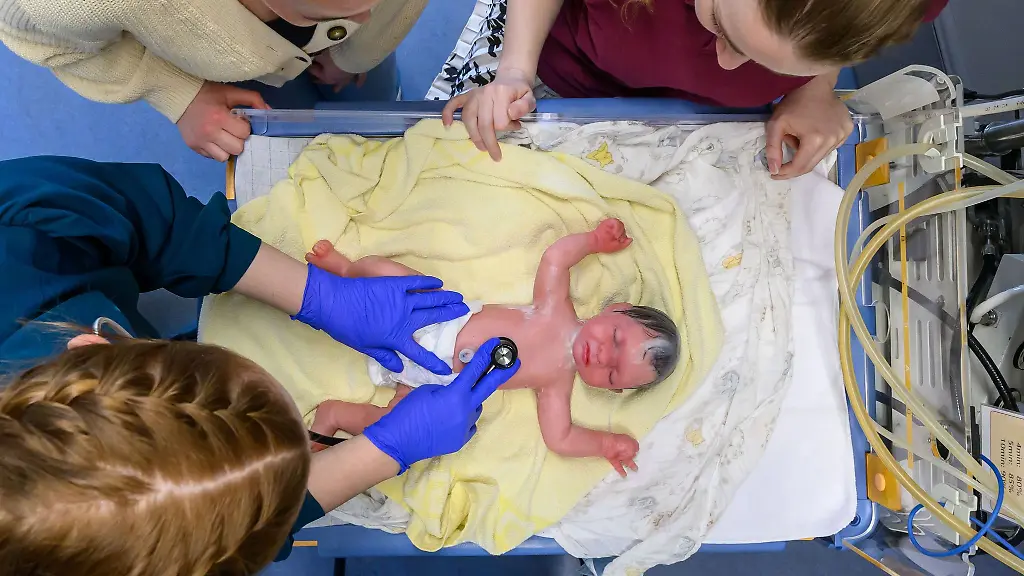 Angehende-Hebammen-ueben-in-einem-neuen-Simulationslabor-der-Universitaetsmedizin-Halle-Saale-die-Untersuchung-eines-Neugeborenen-anhand-einer-lebensechten-Puppe