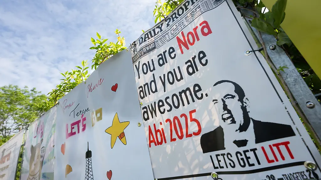 Familie-und-Freunde-wuenschen-den-Prueflingen-mit-Plakaten-ein-gutes-Gelingen