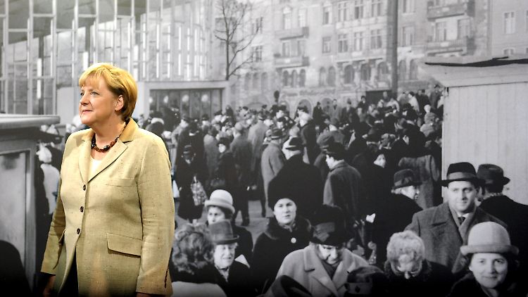 Bundeskanzlerin Merkel  während der Eröffnung der Ausstellung "GrenzErfahrungen. Alltag der deutschen Teilung" vor einem historischen Foto.