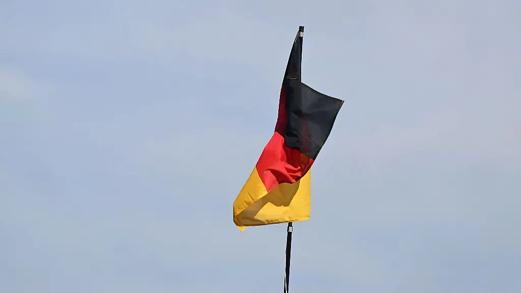 Eine-Deutschland-Fahne-weht-vor-Beginn-eines-Protestmarsches