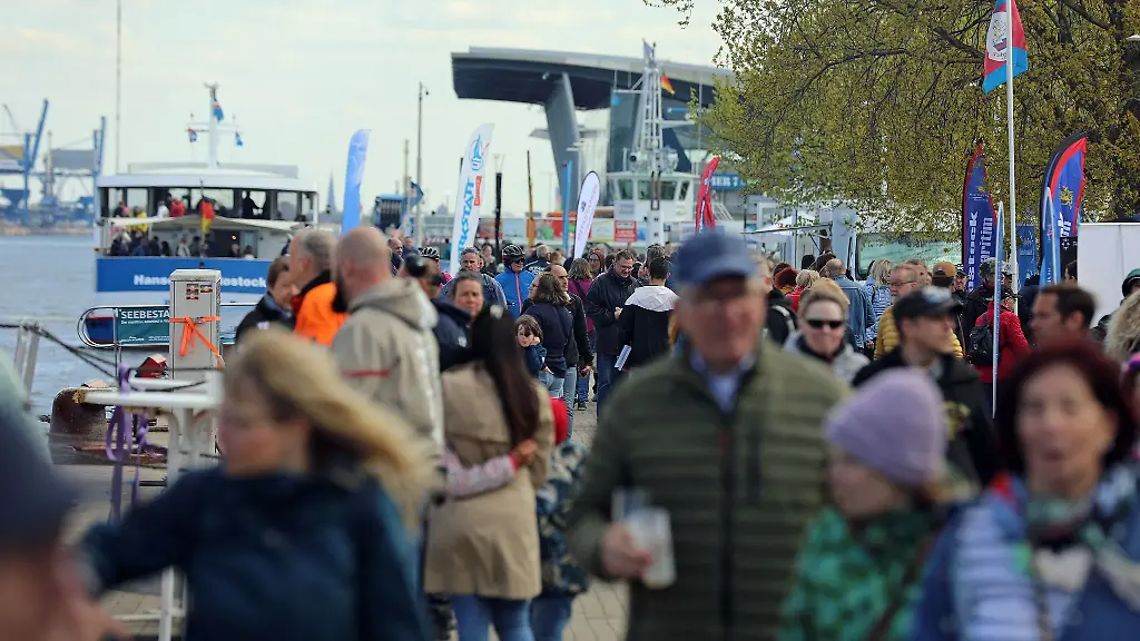 Besucher-des-Fests-spazieren-am-Meer-in-Rostock-Warnemuende