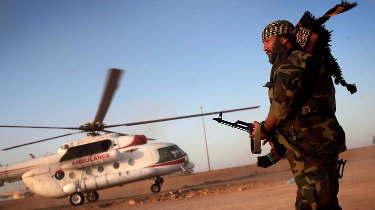 Ein Rebell steht in der Nähe von Sirte vor einem Rettungshubschrauber.