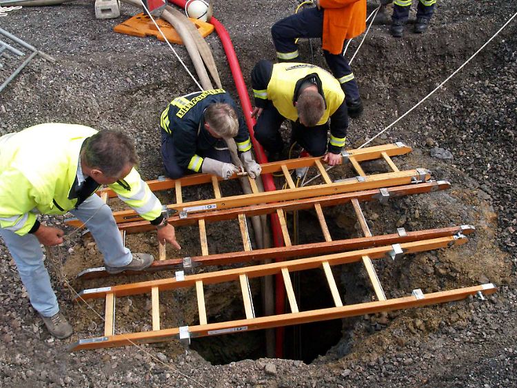 Feuerwehrleute begutachten den Krater.