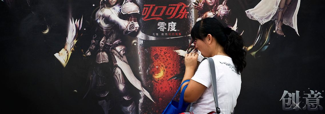 Dialog der Kulturen: Eine Chinesin steht vor einer Cola-Werbung in Peking.