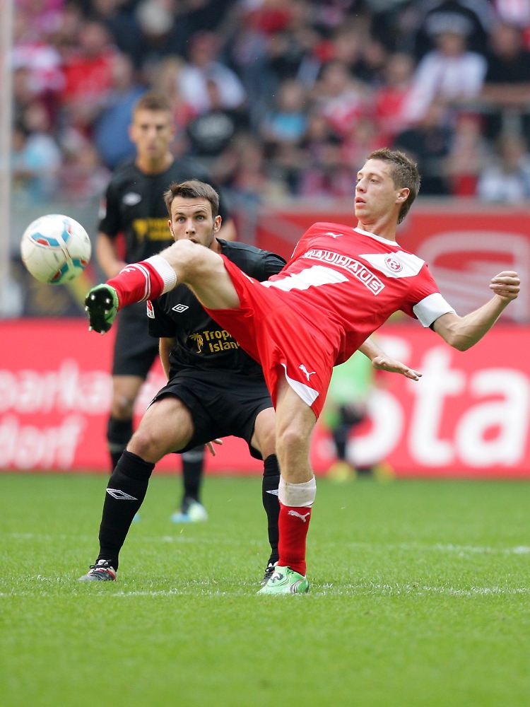 Düsseldorfs Andreas Lambertz (r) und Marc Andre Kruska aus Cottbus versuchen an den Ball zu kommen.