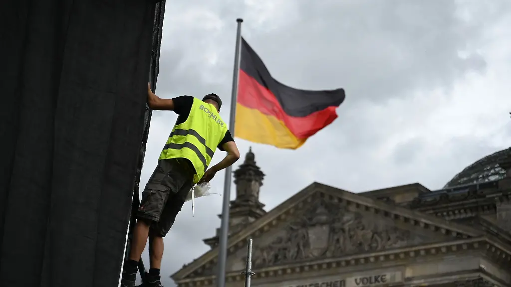 Die-Aufbauarbeiten-laufen-Ein-Arbeiter-befestigt-eine-Plane-zur-Vorbereitung-einer-Projektion-anlaesslich-des-30-Jahrestags-der-Reichstag-Verhuellung