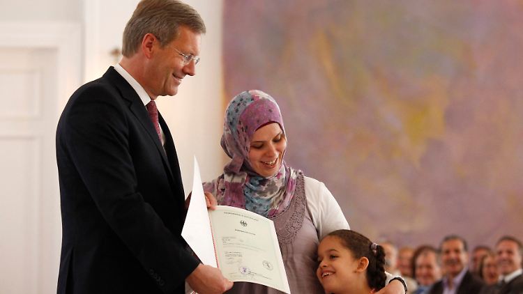 Christian Wulff überreicht die Urkunde an eine Mutter und ihre Tochter.