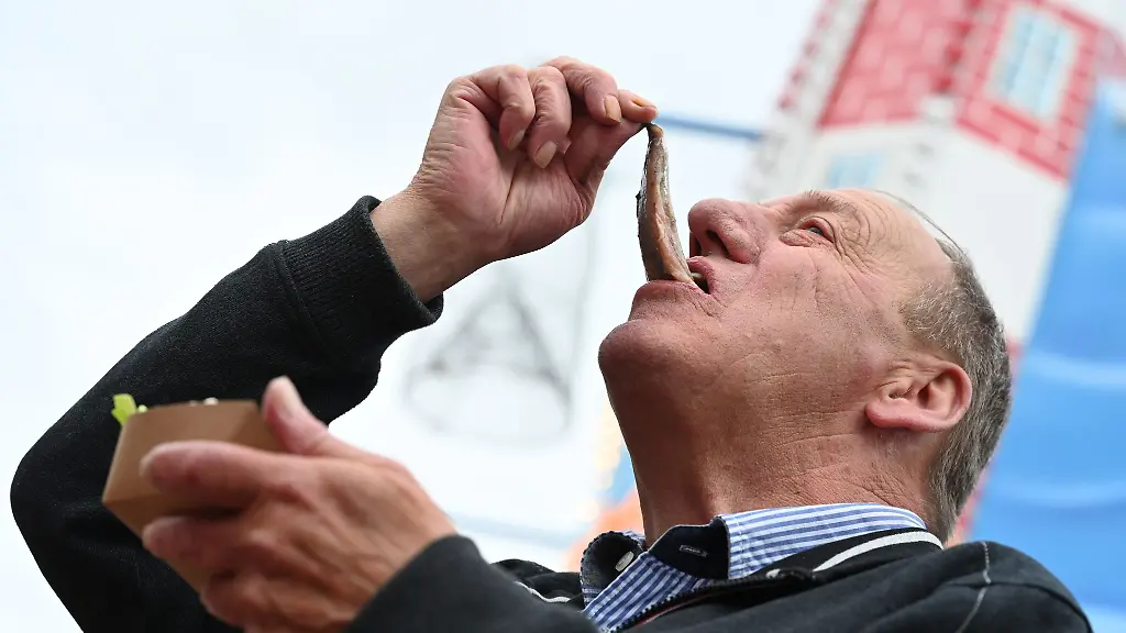 Wohl-bekomm-s-ein-Besucher-isst-Matjes-bei-den-Emder-Matjestagen-auf-die-traditionelle-Art