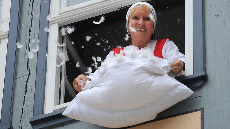 Als "Frau Holle" verkleidet schüttelt Marlu Stoffels aus einem Fenster des neuen Frau-Holle-Museums in Hessisch Lichtenau ihr Kissen aus.