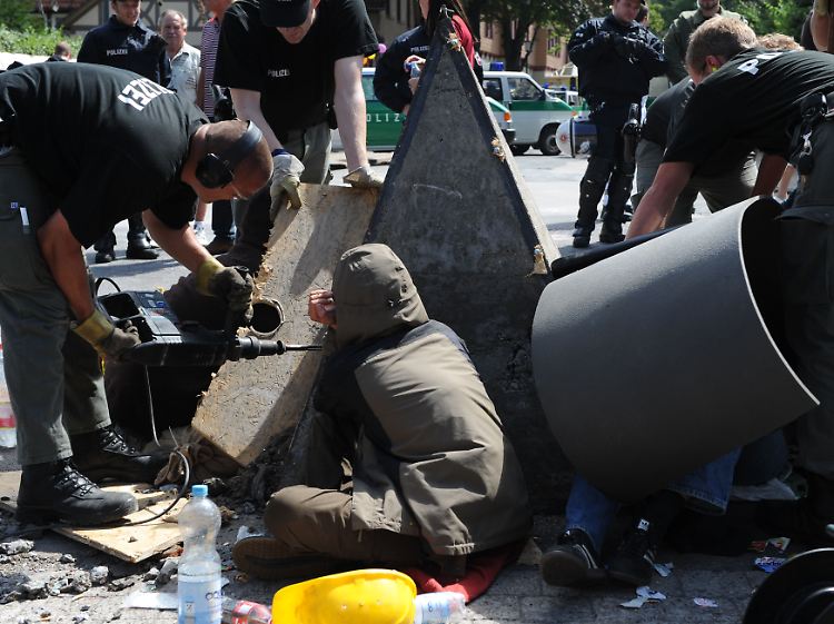 Vor dem Wincklerbad lösen Polizisten einen Gegendemonstranten von einer Betonpyramide.