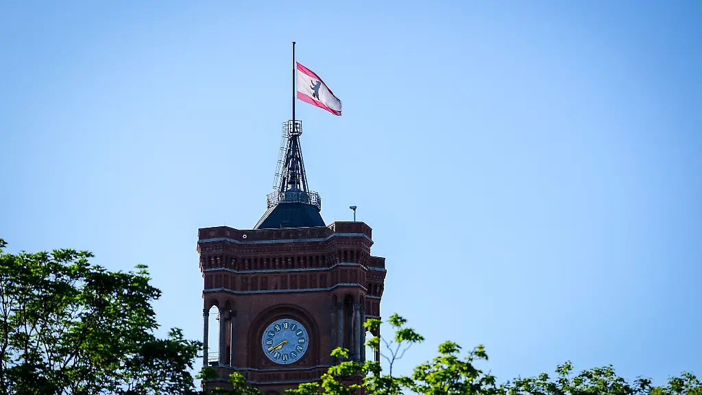 Die-Flagge-an-der-Spitze-des-Roten-Rathauses-weht-am-Morgen-auf-halbmast