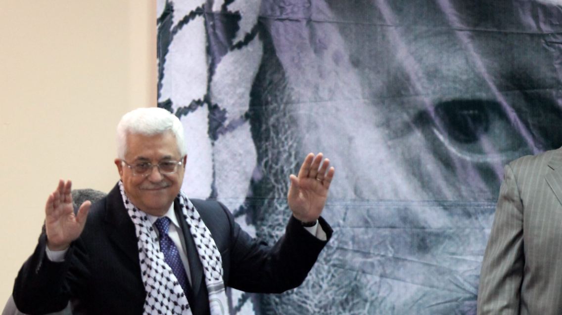 Hinter einem Bild des verstorbenen Palästinenserführers Jassir Arafat nimmt Präsident Abbas den Applaus der Delegierten entgegen.