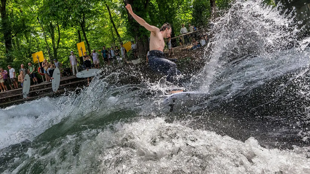 Ab-in-die-erfrischenden-Fluten-bei-dieser-Hitze-geniessen-die-Surferinnen-und-Surfer-eine-Abkuehlung-an-der-Eisbachwelle-im-Englischen-Garten