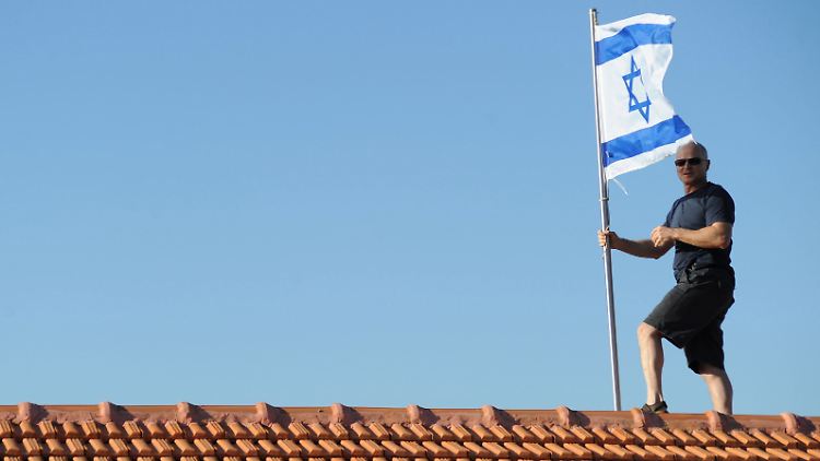 Gilad Schalits Vater Noam hisst auf dem Dach seines Hauses in Mitzpe Hilah die israelische Flagge.