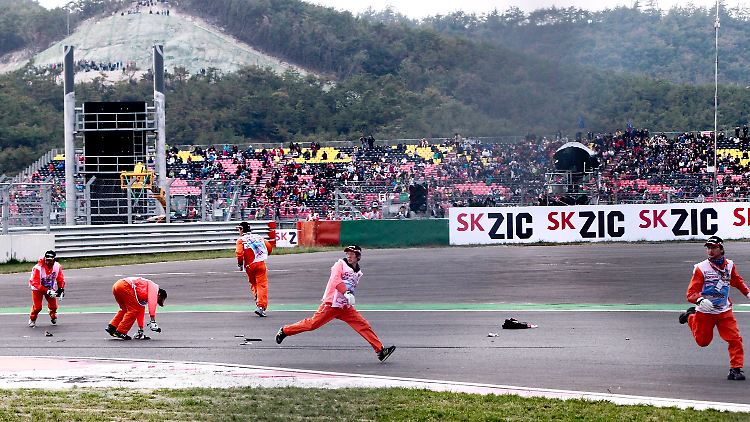 Stewards räumen in Südkorea Trümmerteile von der Strecke.