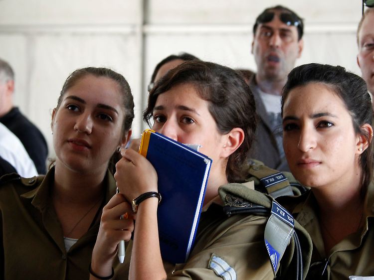Soldatinnen und Soldaten der Presseabteilung der israelischen Armee verfolgen die Berichterstattung im Fernsehen.