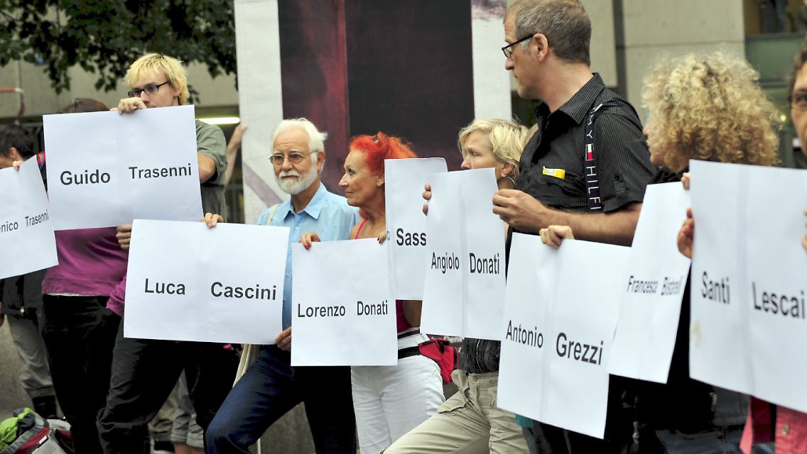 Demonstranten erinnern mit Namensschildern an die 14 Opfer des Massakers in Falzano di Cortona, während vor dem Schwurgericht I in München der Prozess gegen Josef Scheungraber läuft.
