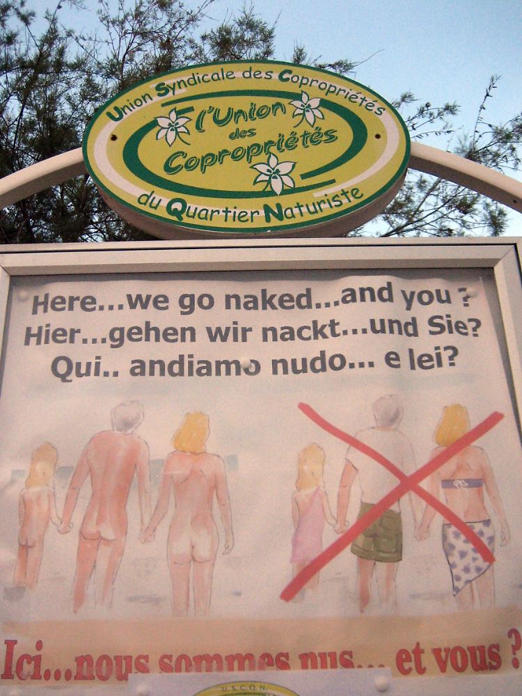 Das Schild am Eingang der Anlage in Cap d'Agde fordert Besucher in verschiedenen Sprachen auf, ihre Kleidung abzulegen.