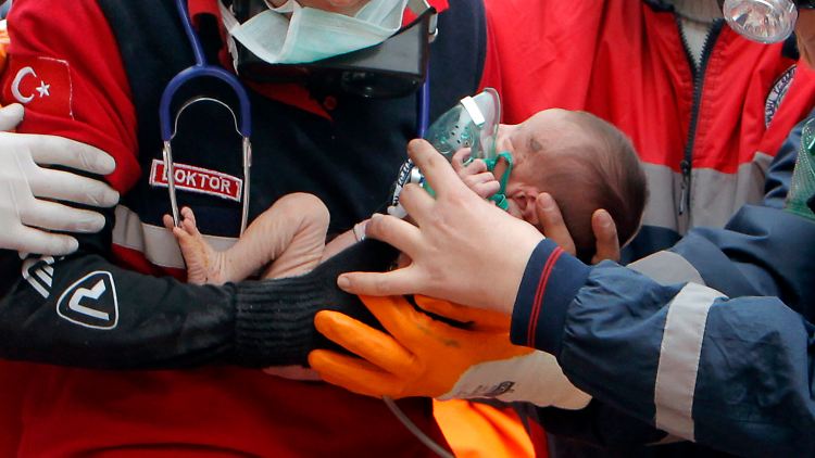 Die Retter halten das Baby auf dem Arm.
