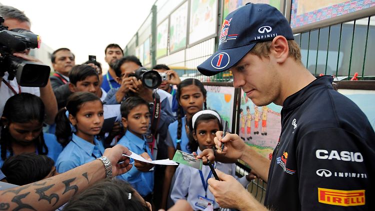 Weltmeister Sebastian Vettel verteilt Autogramme.