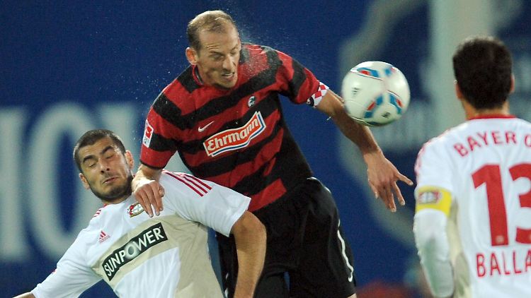 Oliver Barth von Freiburg (M) kämpft mit Eren Derdiyok (l) um den Ball, Ballack schaut zu.