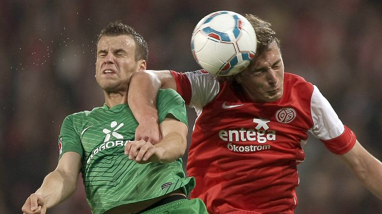 Der Mainzer Julian Baumgartlinger (r) und Bremens Lukas Schmitz (l) versuchen an den Ball zu kommen.