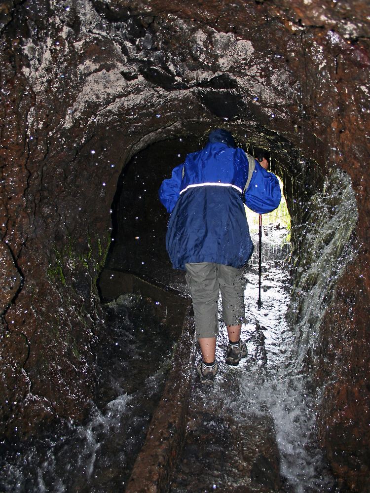 Wasserfall aus der Tunneldecke: Für den Weg zu den Quellen von Marcos y Cordero ist eine Regenjacke ganz nützlich.