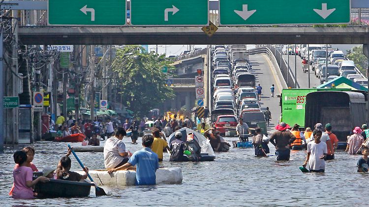 Ein mittlerweile alltägliches Bild in Bangkok: Einwohner waten durch hüfttiefes Wasser.