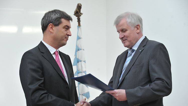 Seehofer (r) übergibt Söder in der Münchner Staatskanzlei seine Ernennungsurkunde.