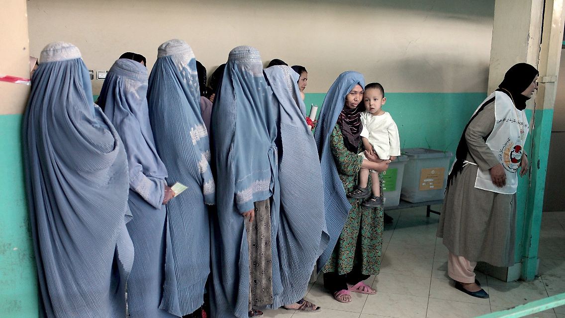 Afghanische Frauen warten mit ihren Stimmkarten in der Hand in einem Wahllokal in einer Moschee in Kabul.