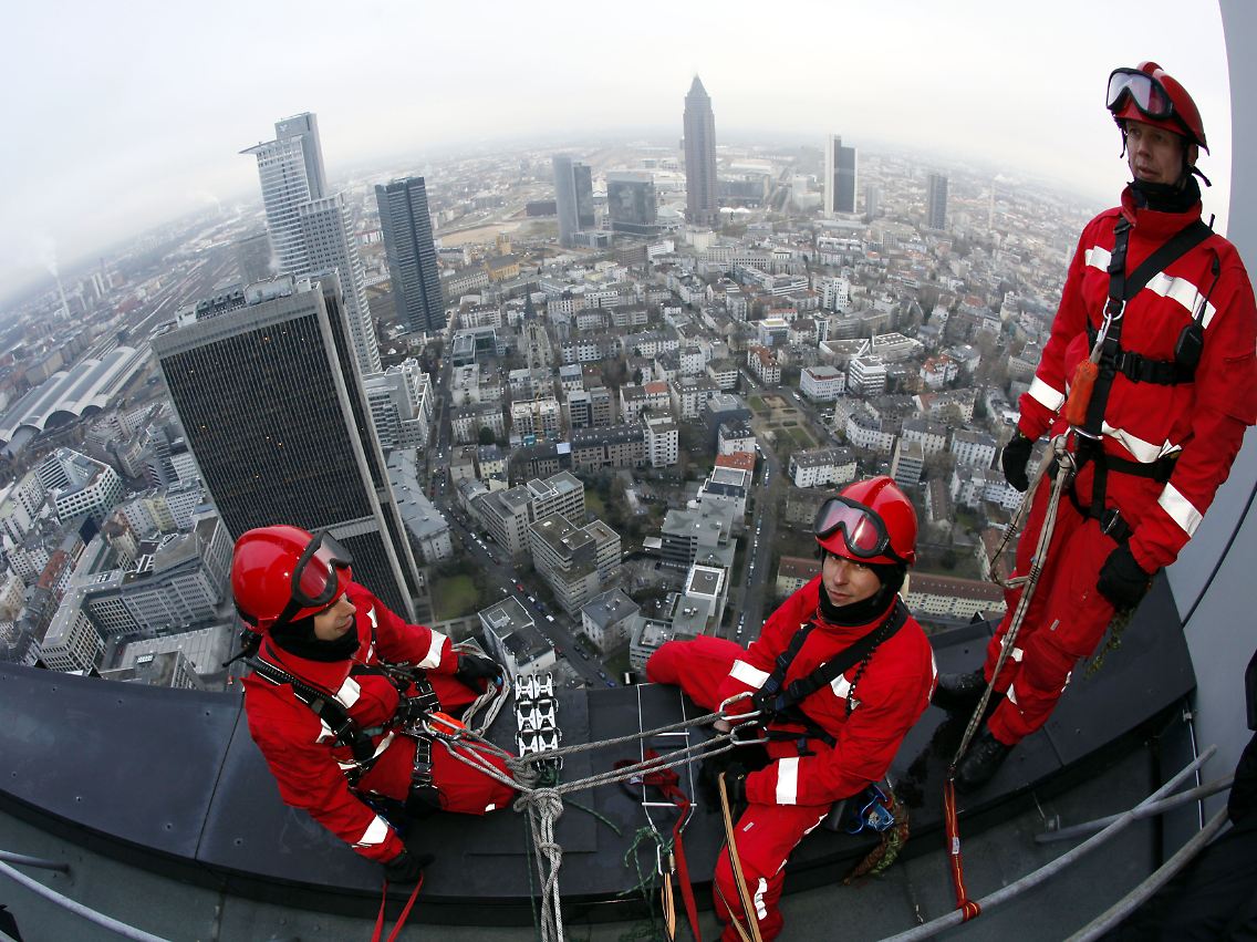 Mehrfach gesichert: Höhenretter der Frankfurter Feuerwehr sitzen auf dem Dach des Trianon-Hochhauses 186 Meter über dem harten Pflaster Frankfurts.